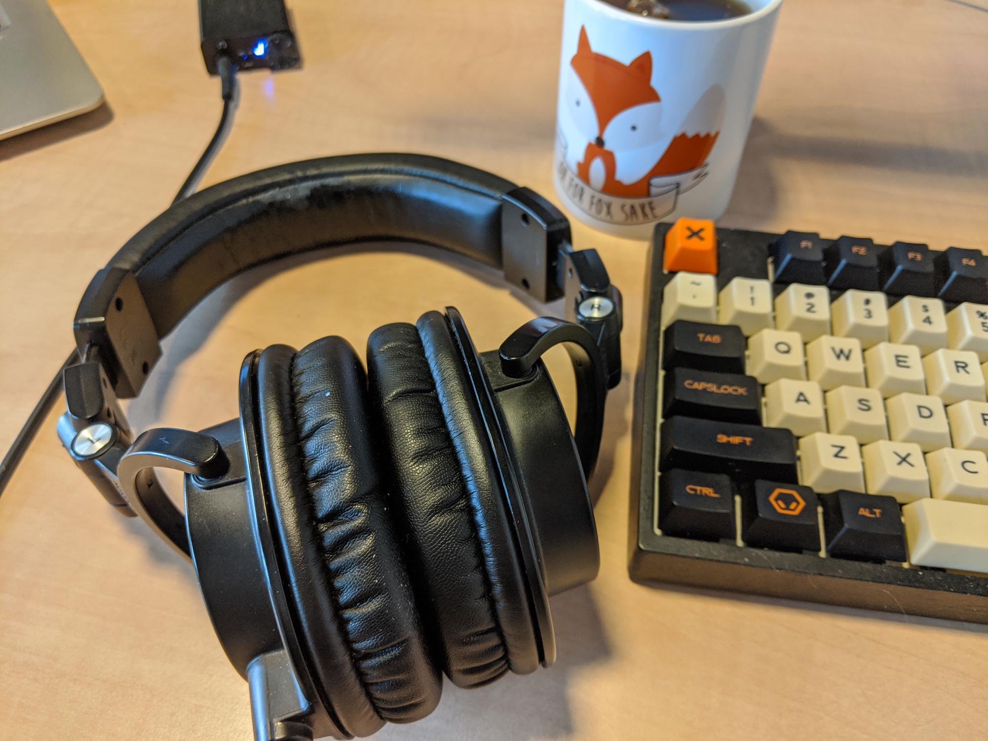 Headphones, keyboard, and mug