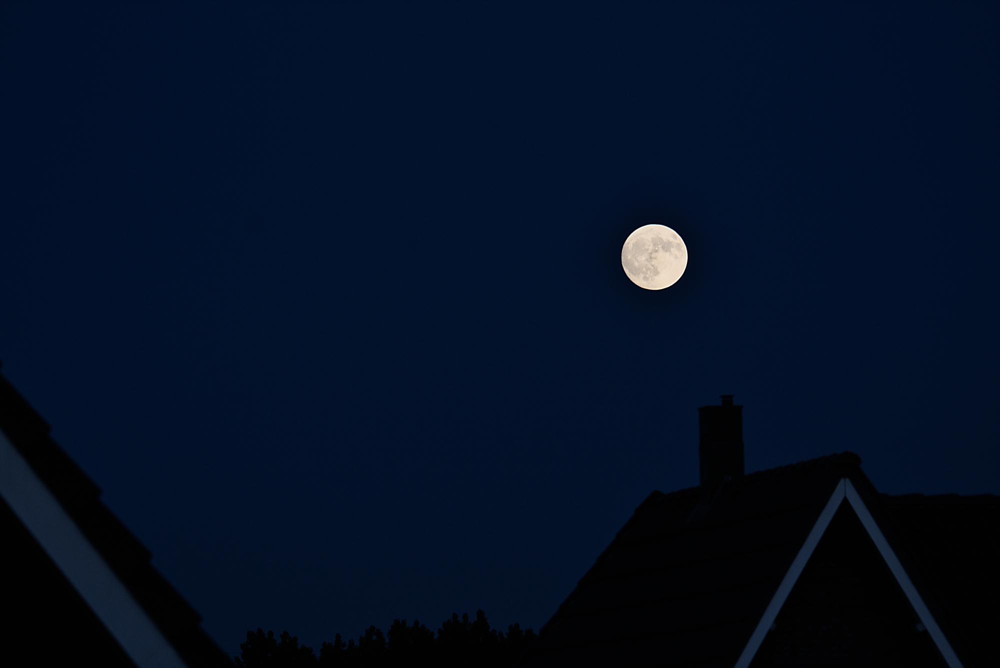 Strawberry Moon over roofs